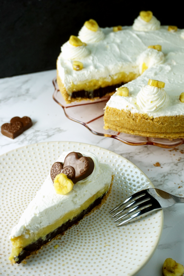 A Slice of black-bottom coconut banana cream pie garnished with a chocolate heart