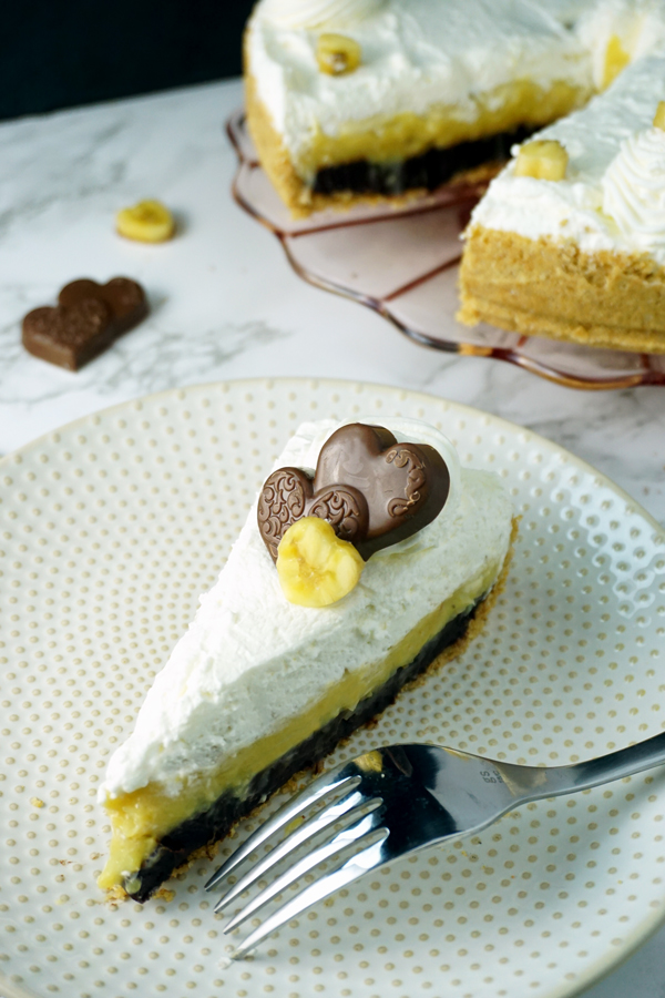 A Slice of black-bottom coconut banana cream pie garnished with a chocolate heart