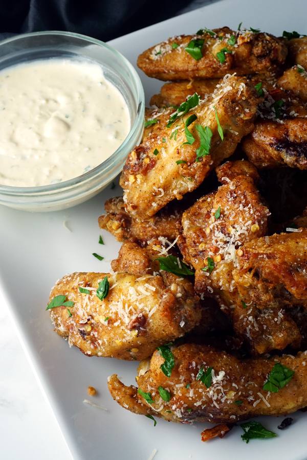 parmesan truffle chicken wings on a plate with garlic dip