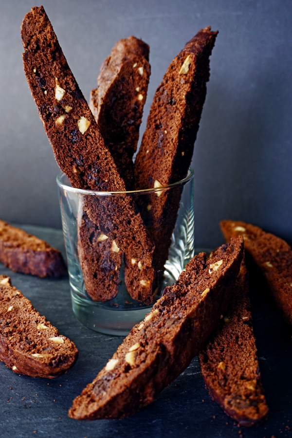 Mocha hazelnut latte biscotti arranged on a black slate tile and in glass