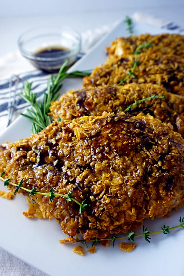 baked crunchy chicken breasts with brown butter honey and herbs on a platter