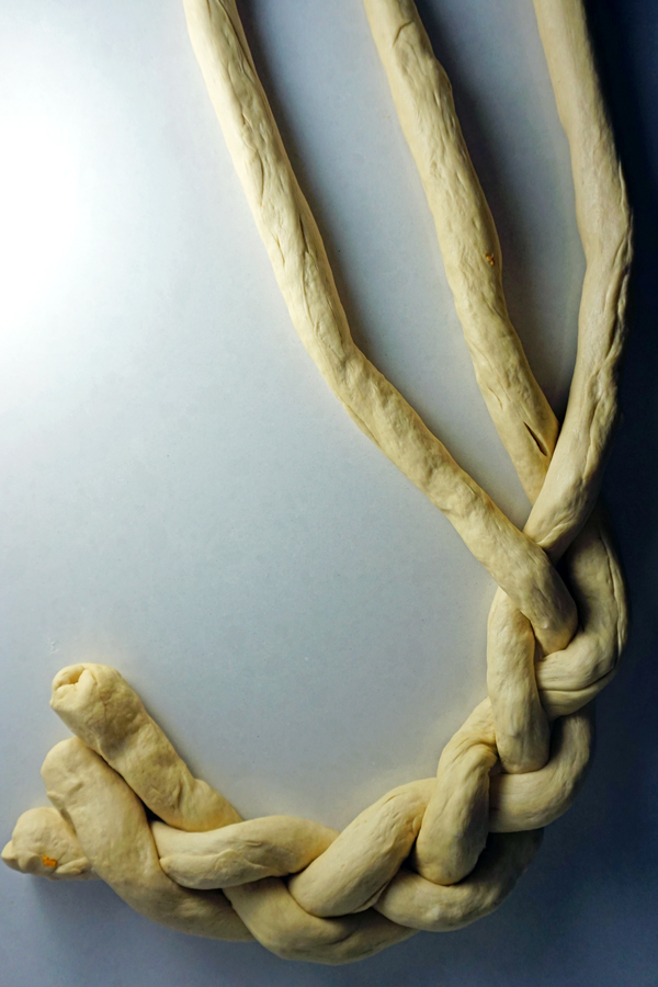bavarian pretzel dough being braided into a pretzel wreath