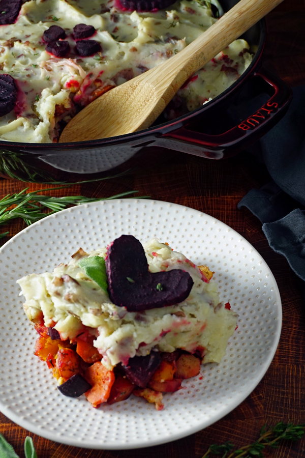 vegan shepherd's pie on a plate with a heart-shaped beet garnish