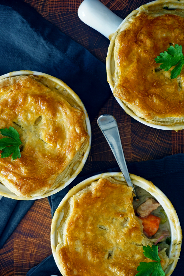 Three corned beef and cabbage pot pies close-up overhead on butcher block