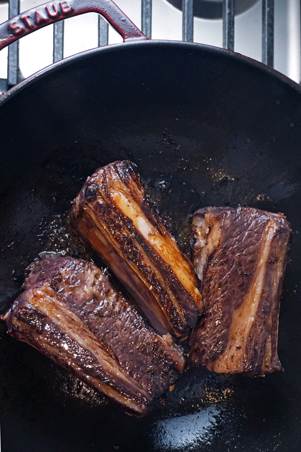 seared beef short ribs in a cast iron pan