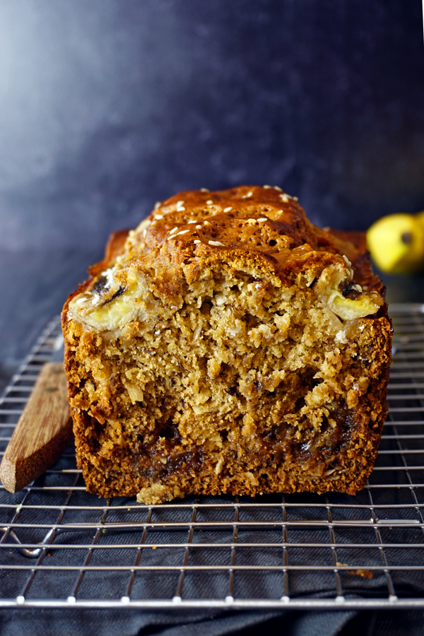 Loaf of tahini banana bread cut open on a wire rack